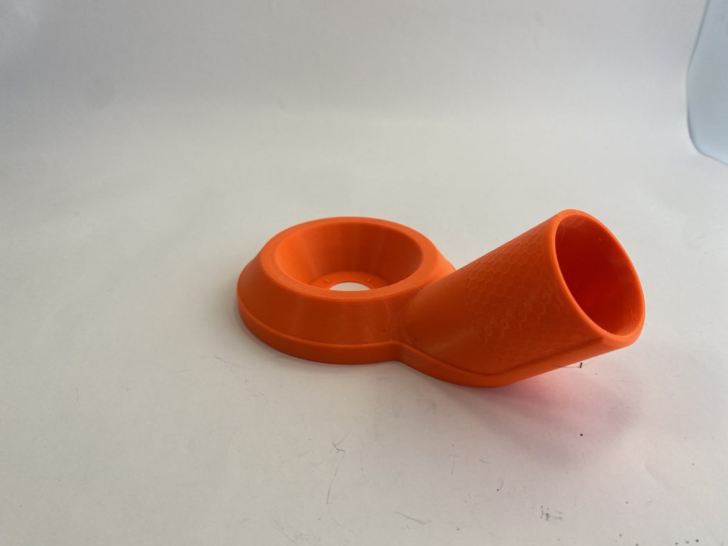 Ein orangefarbener Staubsaugeraufsatz aus dem 3D-Drucker